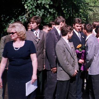 Group of students placing flowers at a monument.