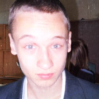 Young man in a suit indoors.