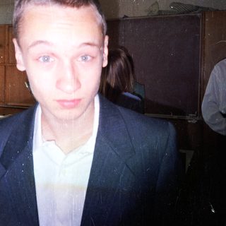 Young man in a suit indoors.