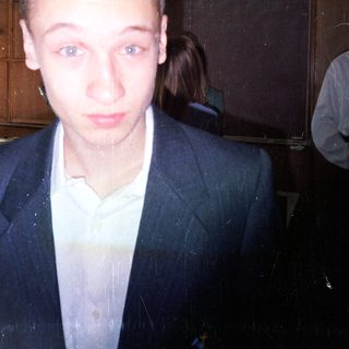 Young man in a suit indoors.