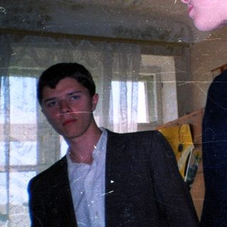 Two people in dimly lit room with vintage decor.