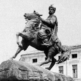 Equestrian statue monument with people observing.