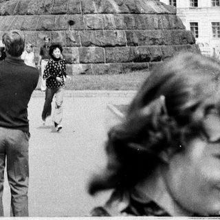 Equestrian statue monument with people observing.