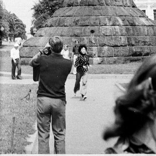 Equestrian statue monument with people observing.