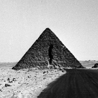 Ancient pyramid on desert road.