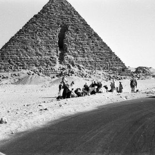 Ancient pyramids with people and vintage car.
