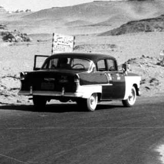 Ancient pyramids with people and vintage car.