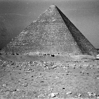 Ancient Egyptian pyramid in desert terrain.