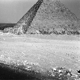 Ancient Egyptian pyramid under construction, desert landscape.