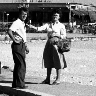 People standing by a seaside roadside.