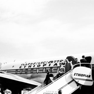 Passengers boarding Ethiopian Airlines plane via staircase.