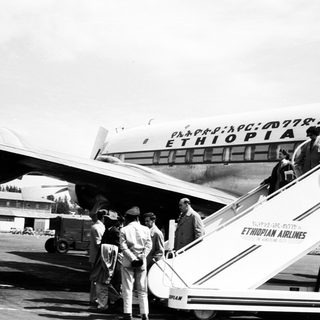 Ethiopian Airlines passengers boarding vintage aircraft.