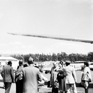 People gathered near a helicopter at an airfield.