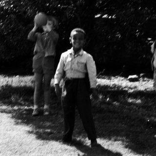 Children playing near a stone monument.
