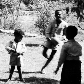 Children playing outdoors in a grassy area.