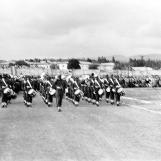 Marching band performing outdoors in vintage parade.