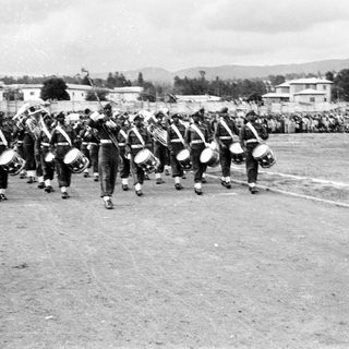 Military band marching with drums and flags.