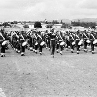 Military band marching with drums and flags.