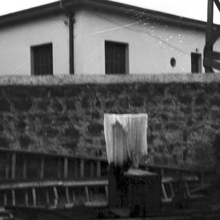 Industrial building with stone wall and fence.