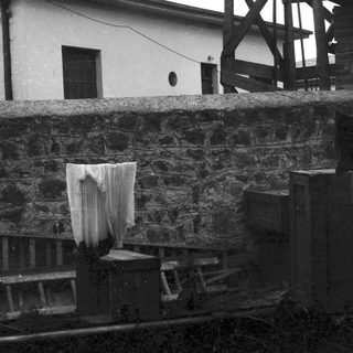 A draped cloth hanging over a weathered stone wall.