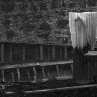A draped cloth hanging over a weathered stone wall.