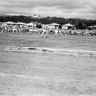 Historic outdoor baseball game with spectators.
