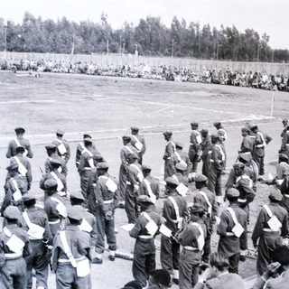 Soldiers standing in formation on a sports field.