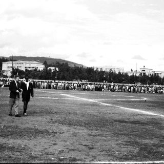 Historic stadium event with large crowd and officials.