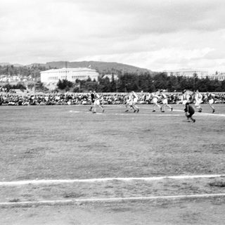 Historic outdoor sports match with spectators.