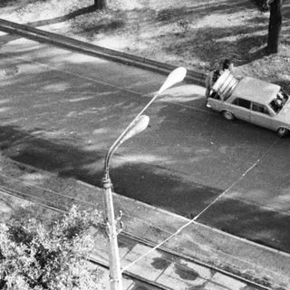 Snow-covered street with two cars driving.