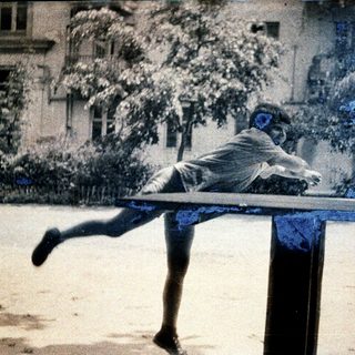 Child mid-air jumping off balance beam.