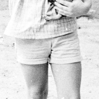 A child holding a small dog outdoors.