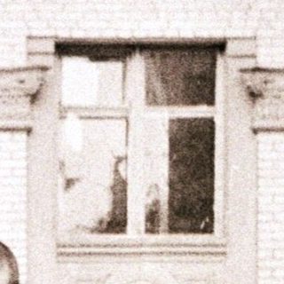 Two boys posing playfully outside an old building.