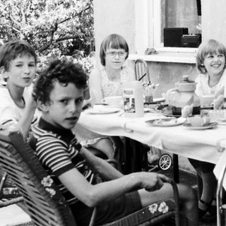 Group of children gathered outdoors for a meal.