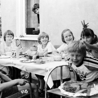 Group of children gathered outdoors for a meal.