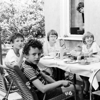 Group of children gathered outdoors for a meal.