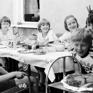 Group of children gathered outdoors for a meal.