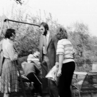 People outdoors in garden, possibly playing frisbee.