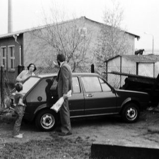 Family loading belongings into a car.