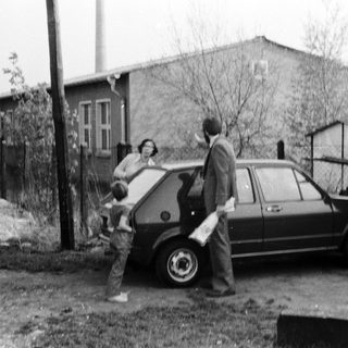Family loading belongings into a car.