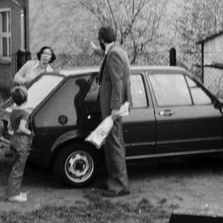 Family loading belongings into a car.