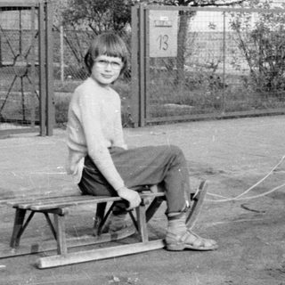 Two children playing with a homemade sled.