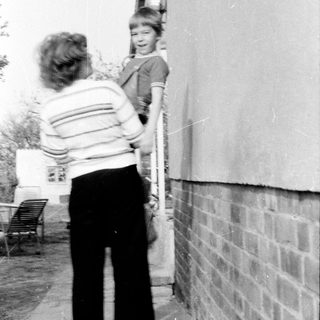 A woman helping a child climb a ladder.