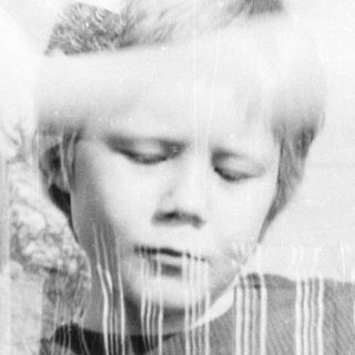 Child holding decorated basket outdoors.
