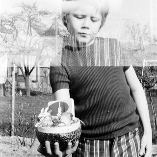 Child holding decorated basket outdoors.