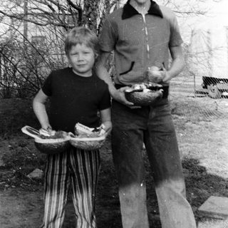 Two people carrying baskets of eggs outdoors.