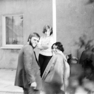 Two people walking outdoors near a building.
