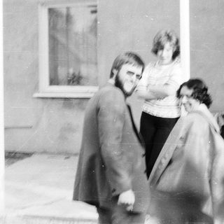 Two people walking outdoors near a building.