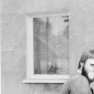 Two people walking outdoors near a building.