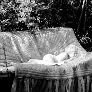 Baby sleeping peacefully in a hanging hammock.